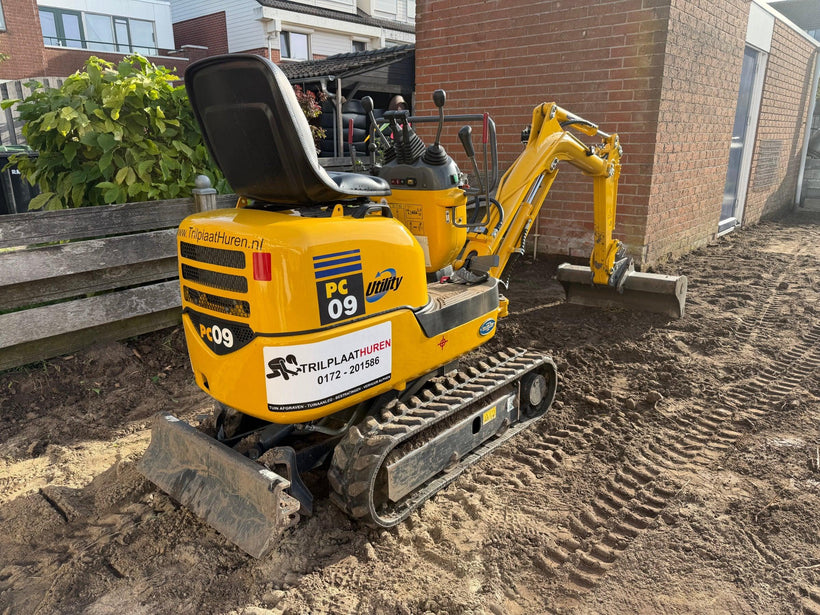 Compacte rupsmini-graafmachine graaft tuin af voor nieuw terras