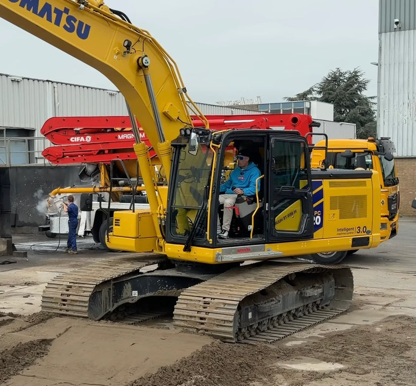 Ervaren machinist bestuurt mini-graafmachine in smalle achtertuin