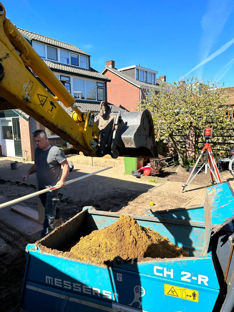 Uitgegraven tuin met vrijgekomen grond klaar voor afvoer