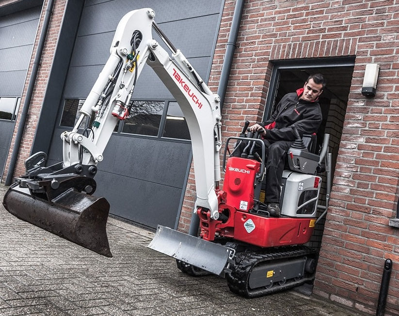 Minigraver door een smalle poort in Alphen aan den Rijn